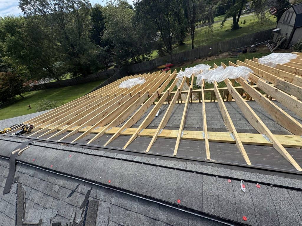 New roof extension rafter framing laid over stripped existing roof during construction phase of roof remodel in Knoxville TN